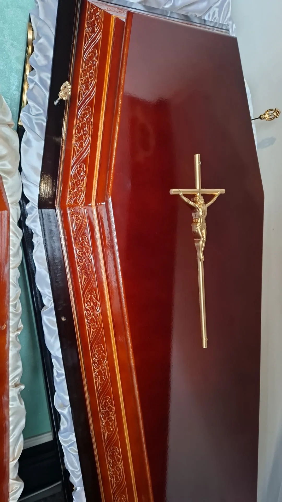 Sicriu vișiniu cu sculpturi și crucifix auriu